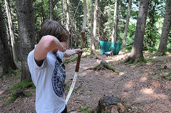 Person beim Bogenschießen im Wald