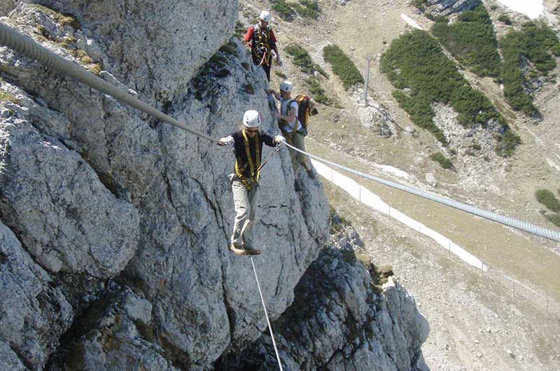 Klettersteiggruppe in der senkrechten Felswand