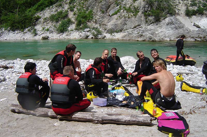 Raftinggruppe sitzt am Ufer der Salza